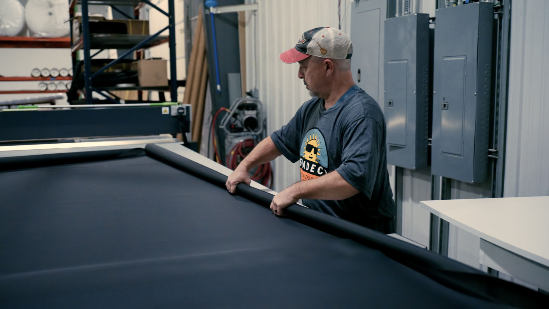 Technician laying out shade fabric for cutting